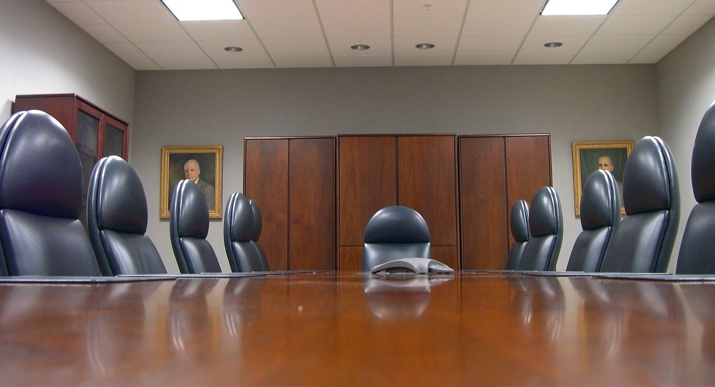 Empty boardroom with leather chairs around a long wooden table